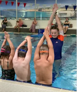Naomi Scott teaching 3 students in the pool