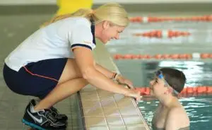 Kim Purnell talking to a student in the pool