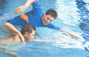 Teacher guiding student with stroke formation in the pool