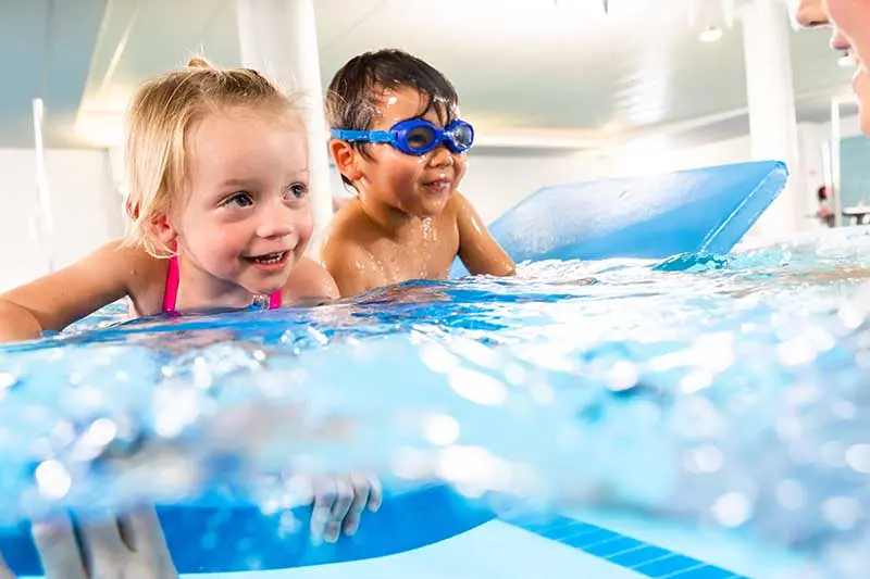 2 water babies splashing in the pool together