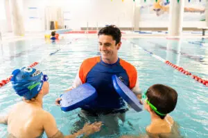 Teacher in the pool with 2 students 