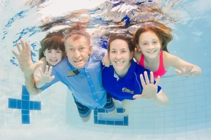 Laurie Lawrence underwater with a swim teacher and students