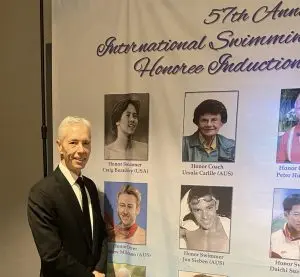 Tim Ford infront of the banner of inductees for Swimming Hall of Fame