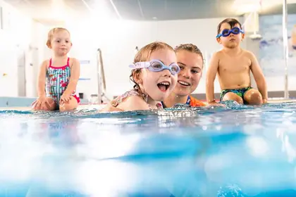 Swim teacher and some students in the water