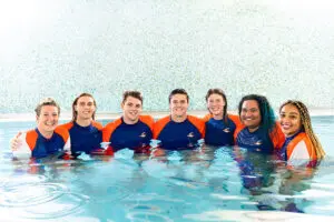 Group photo of Carlile Swimming staff in the pool