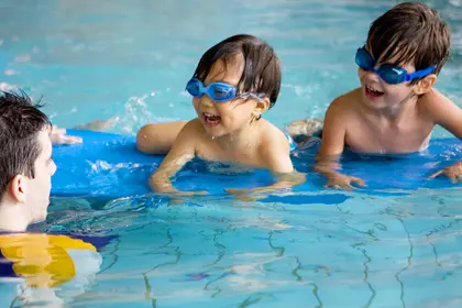 Two young boys splashing in the water