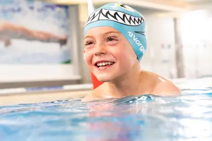 young boy smiling in the pool