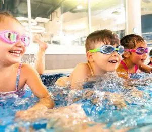 3 students kicking in the water giggling