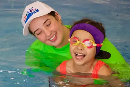 Swim teacher and student smiling in the pool together
