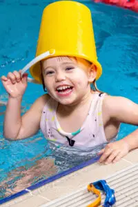 Student sitting in the pool laughing