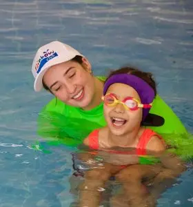 Mum and daughter in the pool smiling together