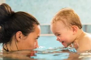 Mum and baby smiling in the pool together
