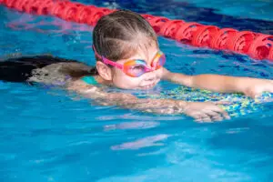 Student swimming with kickboard