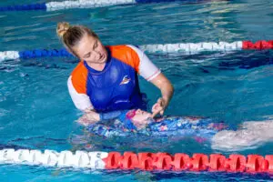 Swim teacher helping student in the pool