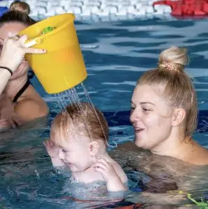Baby enjoying water babies class with mum