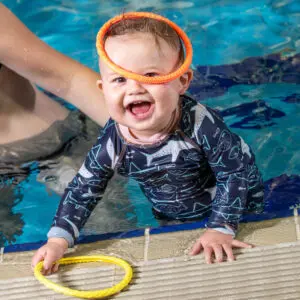 Baby smiling and playing in the pool
