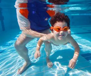 Student smiling underwater