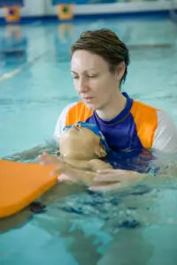 Student learning to float with help of teacher