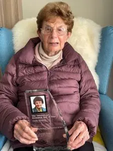 Ursula Carlile holding her Swimming Hall of Fame trophy