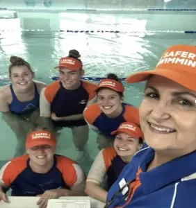 Ginny Shanley and staff smiling in the pool