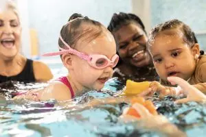 Babies and mums in the pool smiling together
