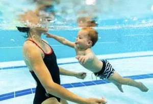 Student swimming towards mum in the pool