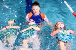 Teacher guiding students in the pool