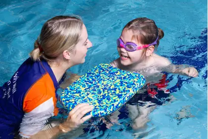 Swim Teacher and young boy smiling in pool