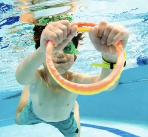 Student holding pool ring underwater