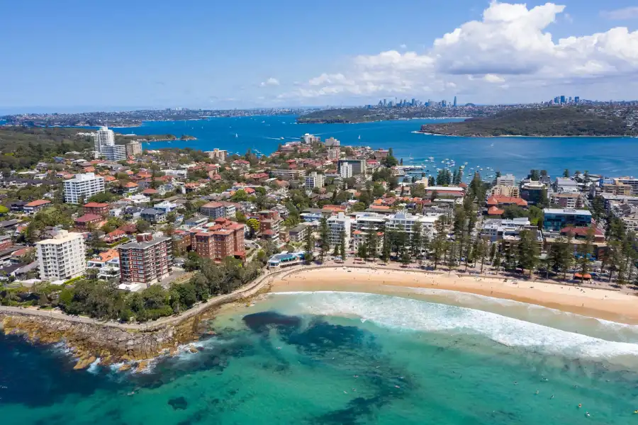Aerial view of Sydney’s Northern Beaches coastline with ocean, sand, and headlands.