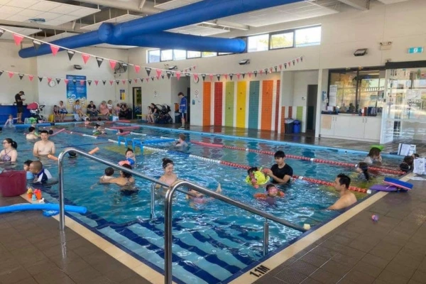 Karrinyup swimming lessons showing multiple parents and children in indoor heated pool.