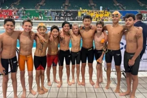 10 Carlile Swim Team members lined up beside the side of the pool